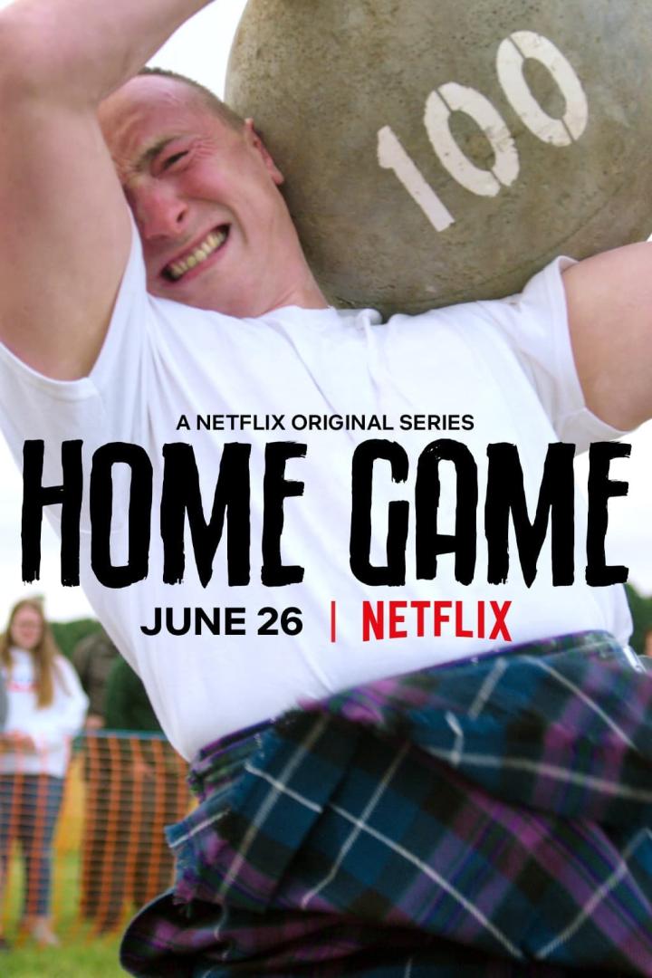 Ein Mann im Kilt stemmt einen schweren Stein mit der Aufschrift „100“ über seinen Kopf.