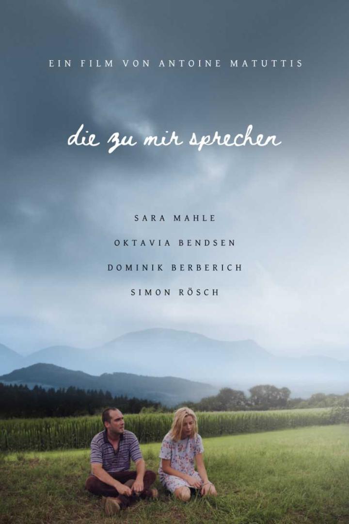Das Filmplakat für „Die zu mir sprechen“ zeigt zwei Menschen vor einer Hügellandschaft.