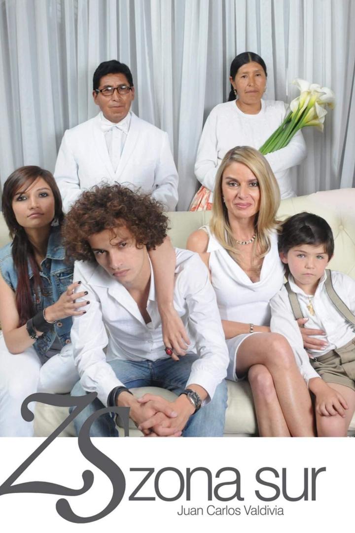 Eine formelle Aufnahme einer Familie, die auf einem Sofa vor einem weißen Vorhang sitzt.