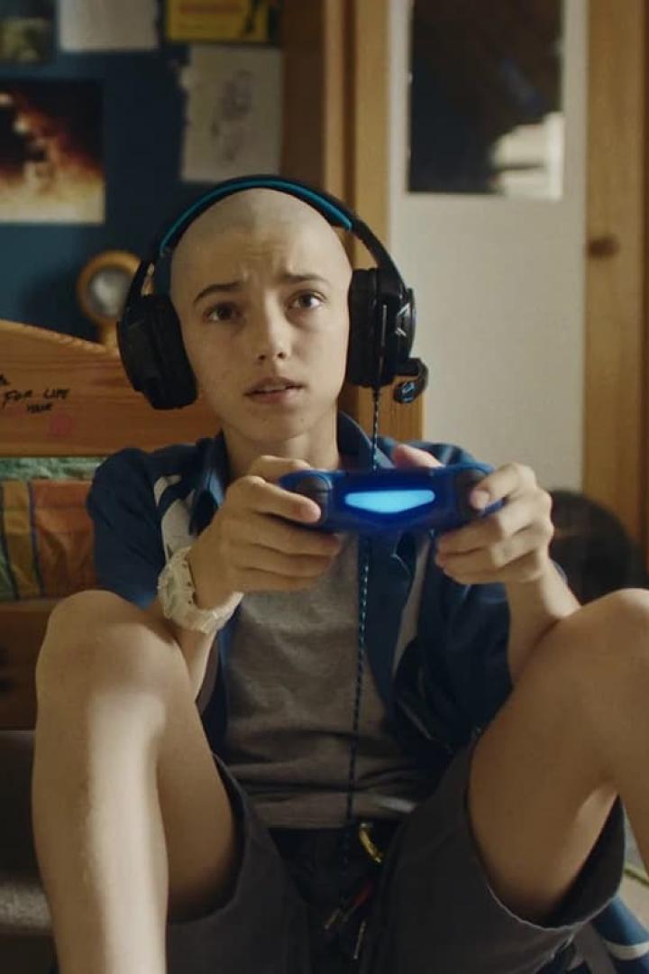 Ein junger Mann mit Kopfhörern spielt Videospiele mit einem Controller.
