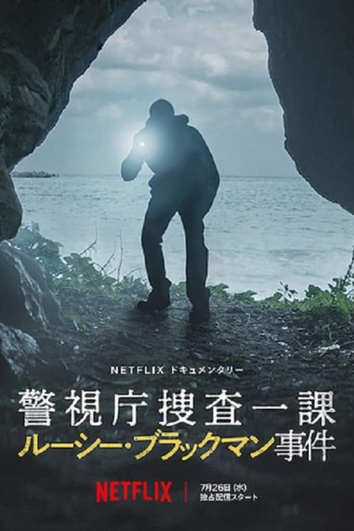 Ein Mann mit einer Taschenlampe steht am Eingang einer dunklen Höhle mit Blick auf das Meer.