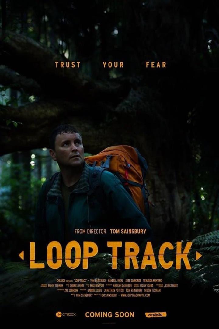 Ein Mann mit Rucksack blickt im Filmposter von „Loop Track“ nach oben.