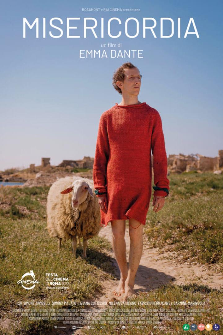 Das Filmplakat für „Misericordia“ zeigt einen Mann im roten Kleid und ein Schaf vor einer Ruinenlandschaft.