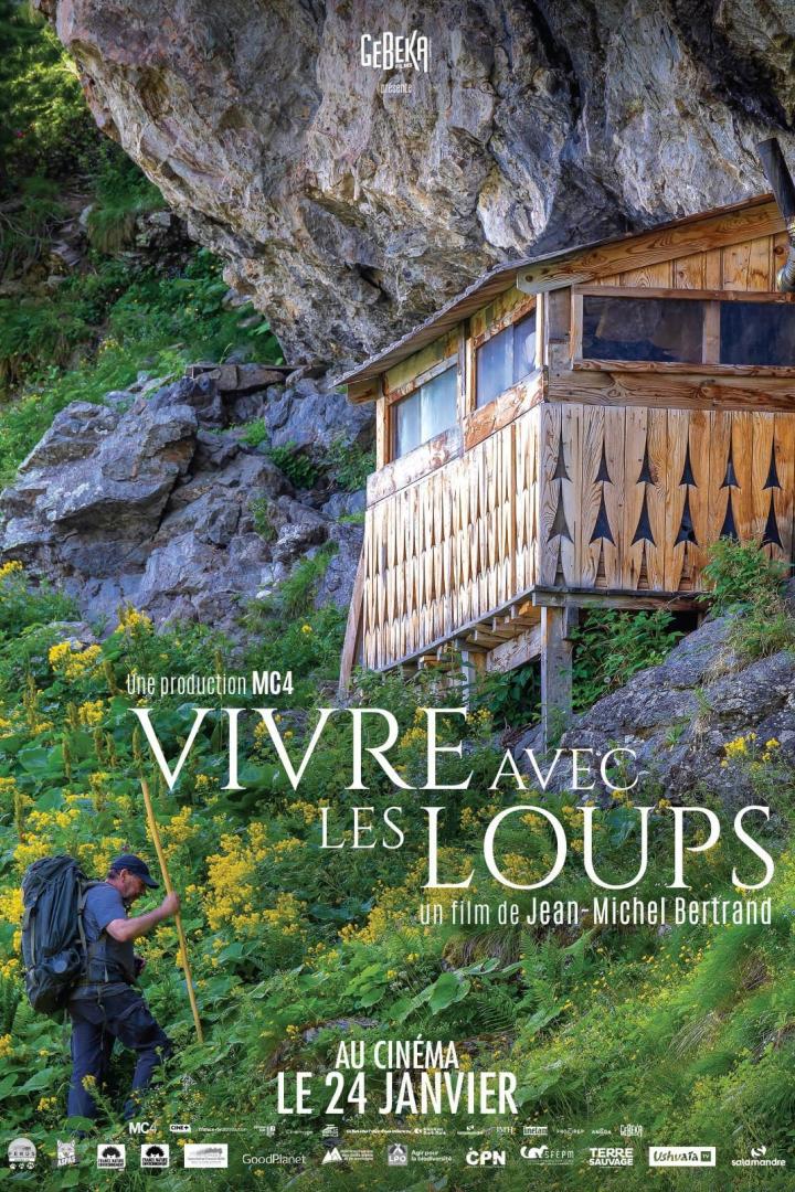 Ein Mann wandert in der Natur; im Hintergrund das Filmplakat „Vivre avec les loups“.