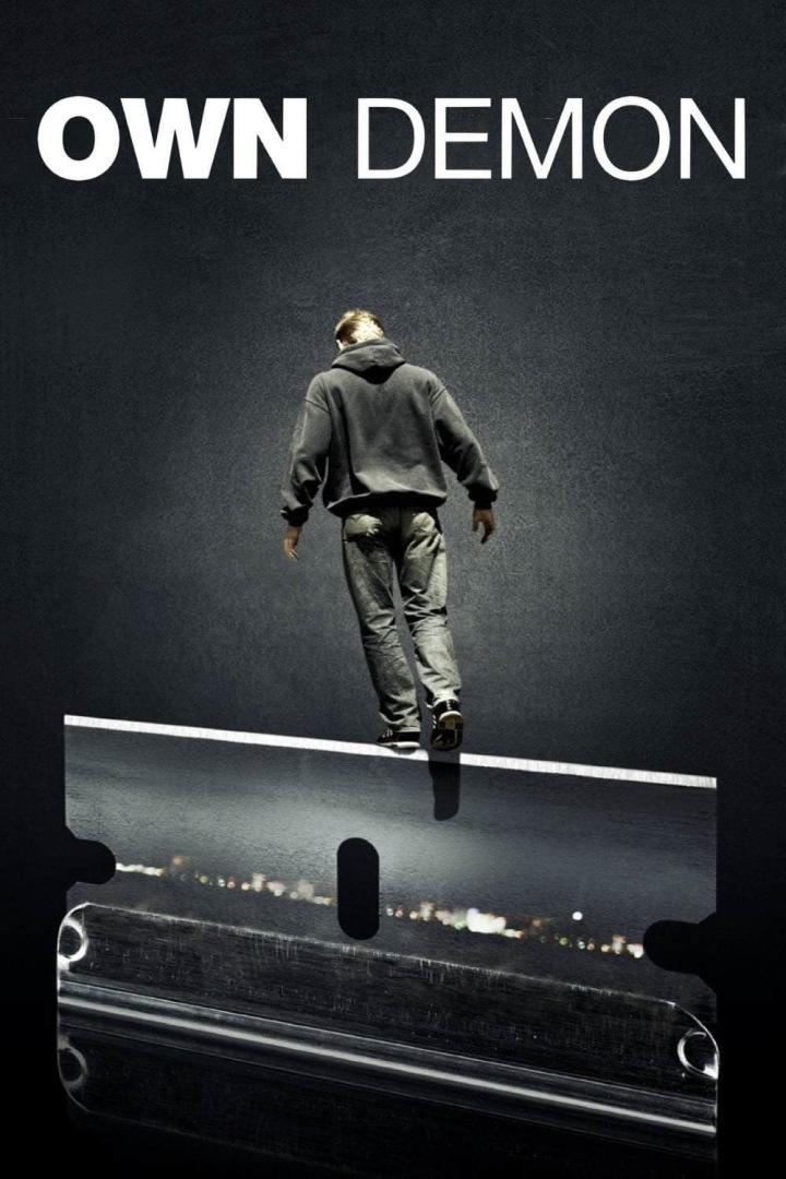 Ein Mann balanciert auf einer Rasierklinge; darüber der Schriftzug „Own Demon“.