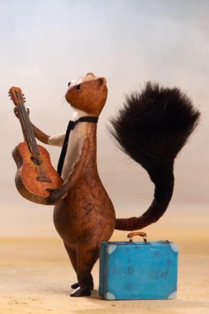 Ein Eichhörnchen mit Krawatte hält eine Gitarre neben einem blauen Koffer.