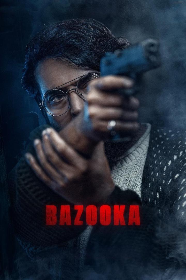 Ein Mann mit Brille zielt mit einer Pistole, im Vordergrund der Schriftzug „Bazooka“.