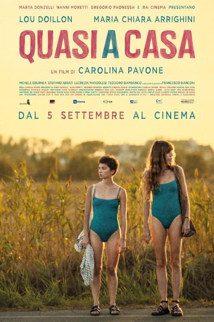 Das Filmplakat für „Quasi a Casa“ zeigt zwei junge Frauen in Badeanzügen vor einer sommerlichen Landschaft.