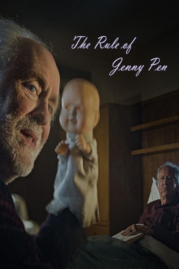 Ein Mann hält eine unheimliche Puppe in der Hand, während ein anderer Mann im Bett liegt.