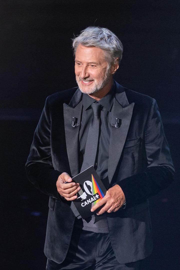 Ein Mann im Anzug hält eine Broschüre von Canal+ in der Hand.