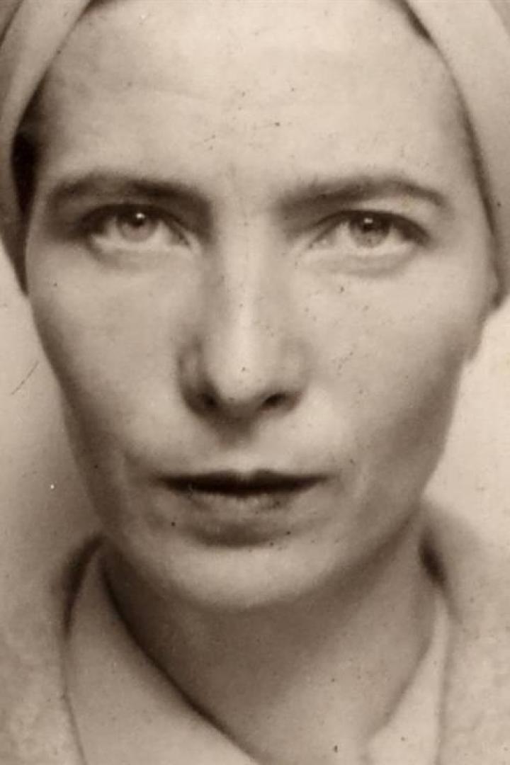 Schwarzweiß-Porträt einer Frau mit ernstem Blick und Turban.