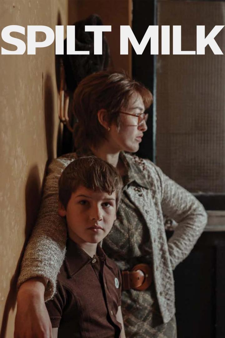 Ein Junge lehnt an seine Mutter, im Hintergrund der Titel „Spilt Milk“.