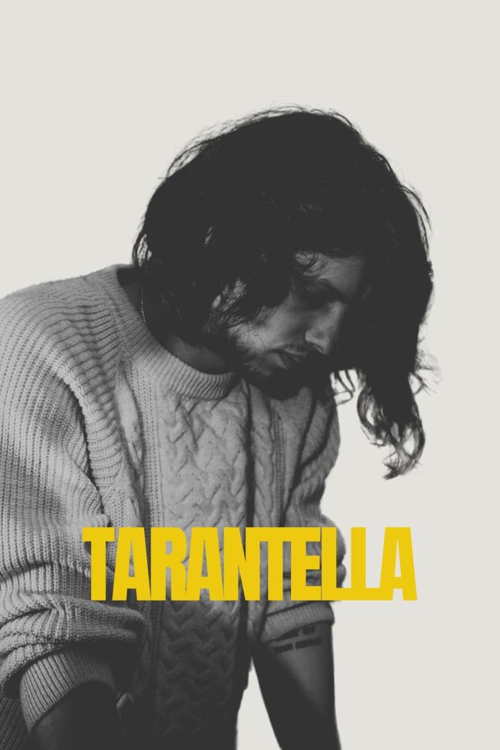 Ein Mann mit langen Haaren und einem Pullover blickt nach unten. Im Vordergrund steht das Wort „Tarantella“.