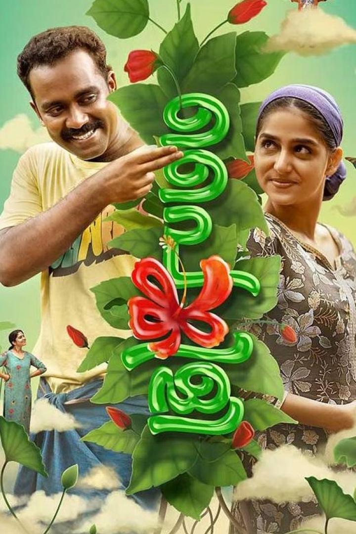 Ein Mann und eine Frau stehen vor einer grünen, blumengeschmückten Schrift.