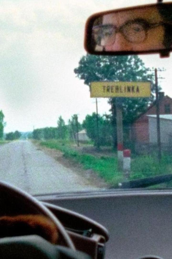 Blick aus einem Auto auf ein Ortsschild von Treblinka.