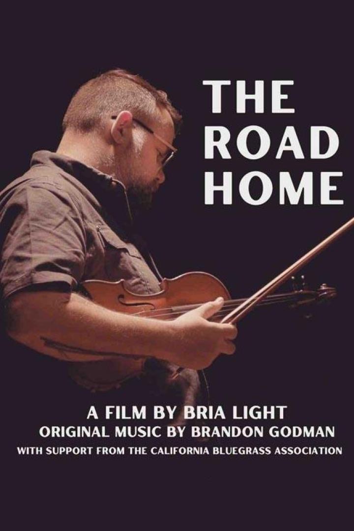 Ein Mann mit Brille spielt Geige; Filmposter für „The Road Home“.