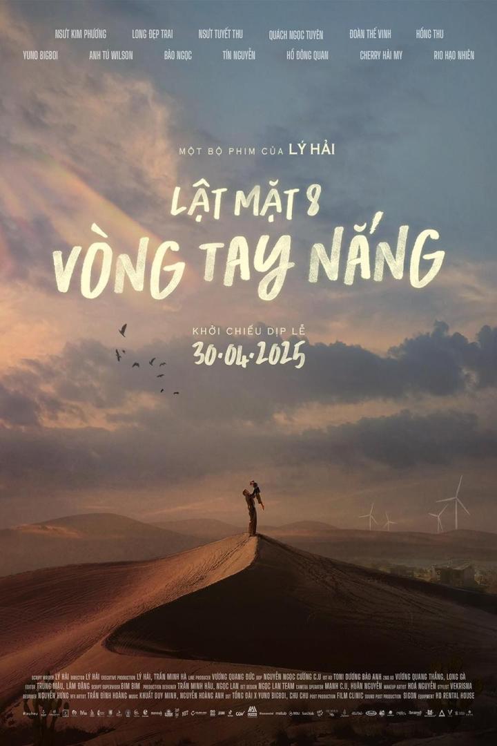 Ein Mann steht mit einem Kind auf einer Sanddüne, im Hintergrund Windräder. Plakat für „Lật Mặt 8: Vòng Tay Nắng“.