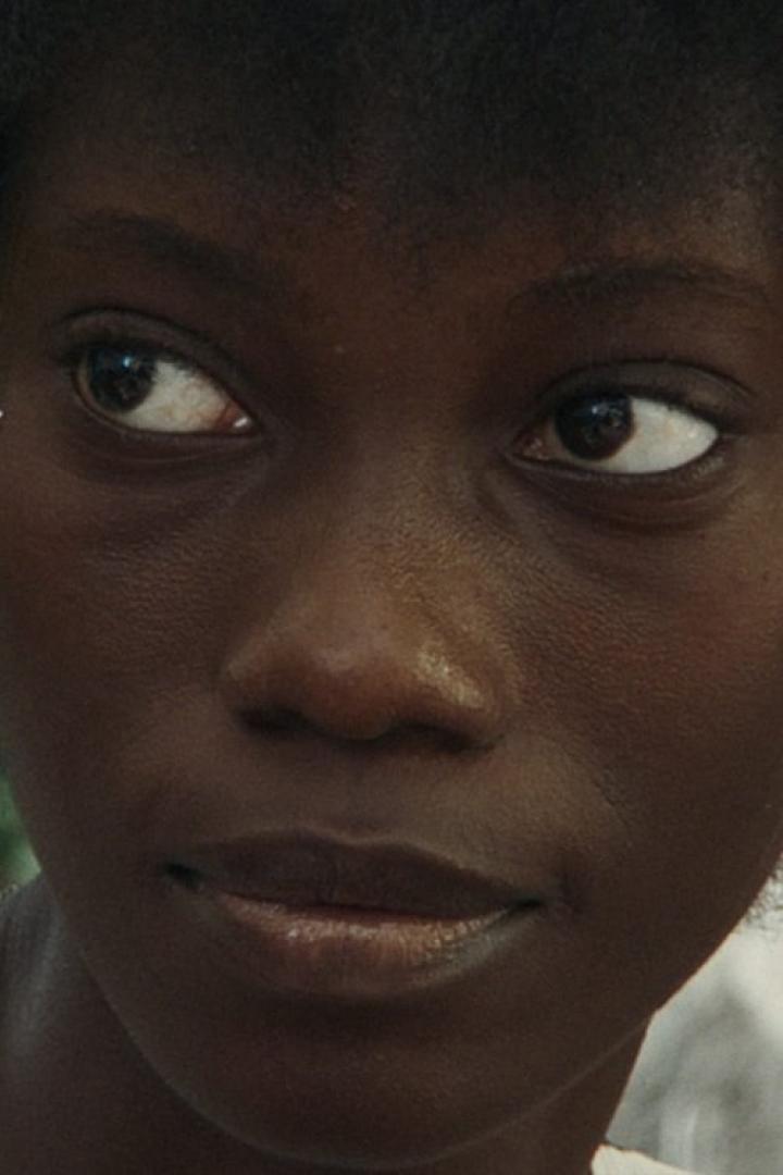 Nahaufnahme vom Gesicht einer jungen, dunkelhäutigen Frau.