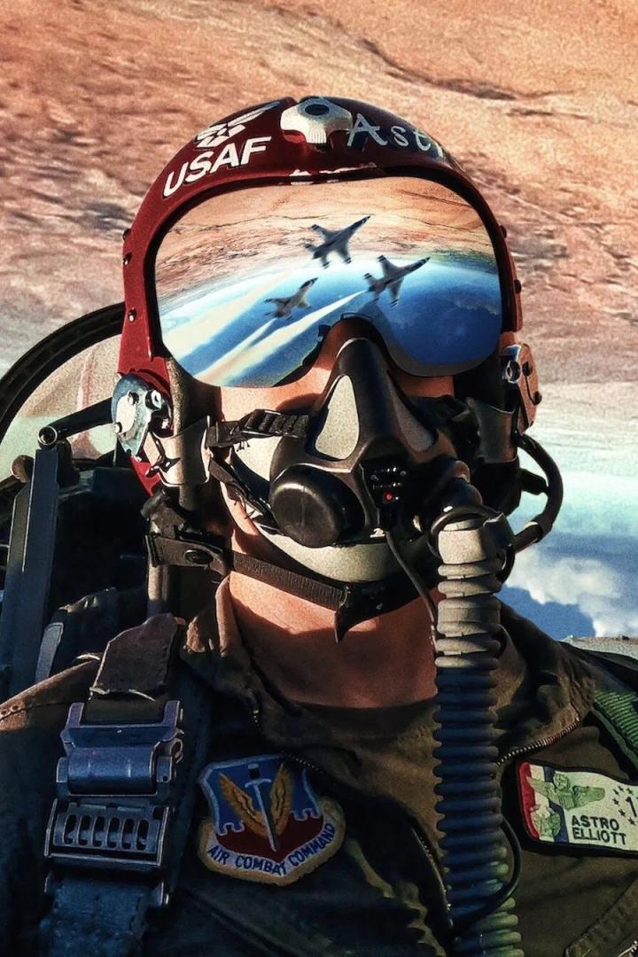 Ein Pilot der US-Luftwaffe mit Helm und Maske, im Visier spiegeln sich startende Kampfjets.