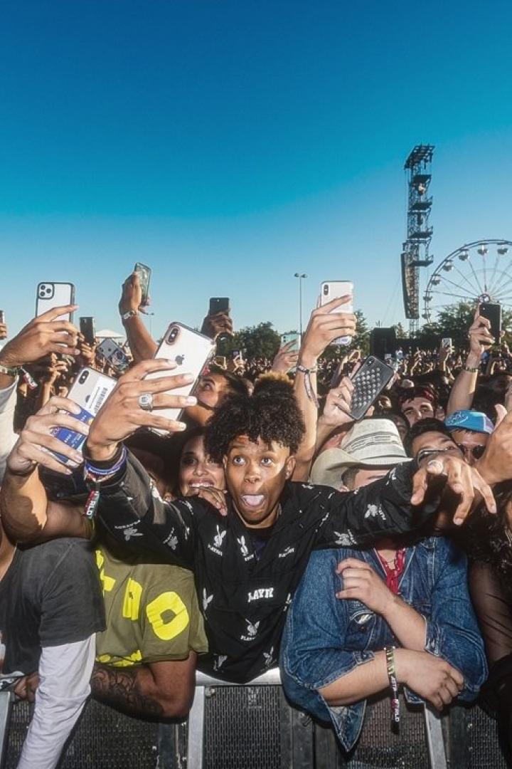 Eine Menschenmenge filmt und fotografiert ein Konzert mit ihren Handys.