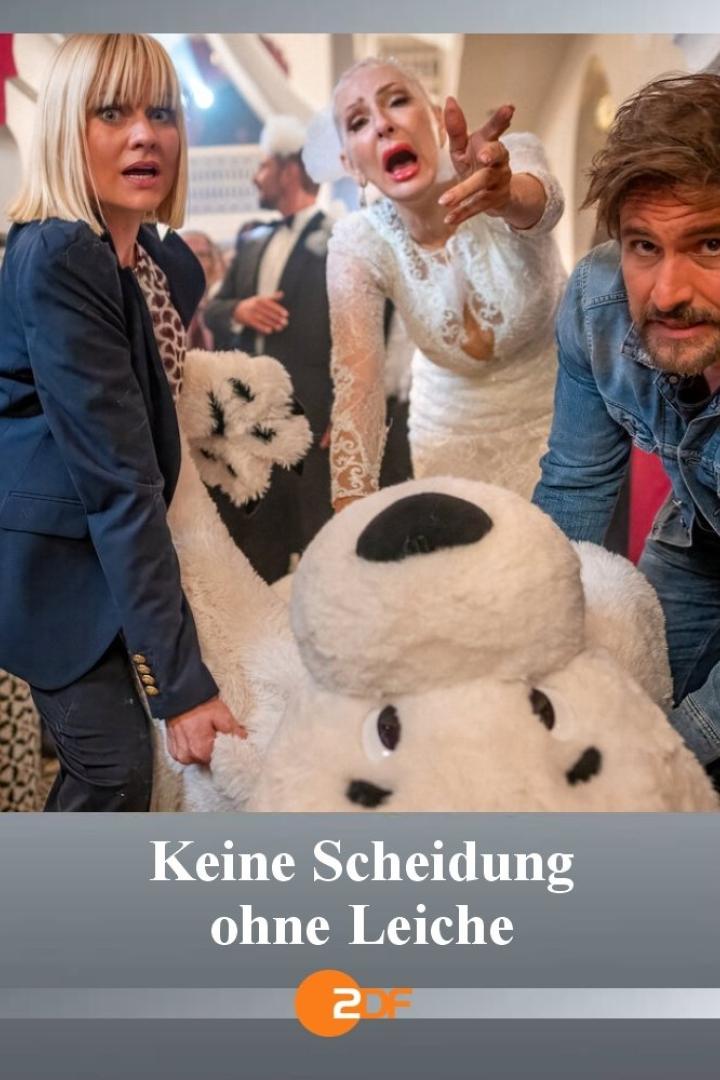 Szene aus „Keine Scheidung ohne Leiche“ mit drei schockierten Personen und einem großen Teddybär.
