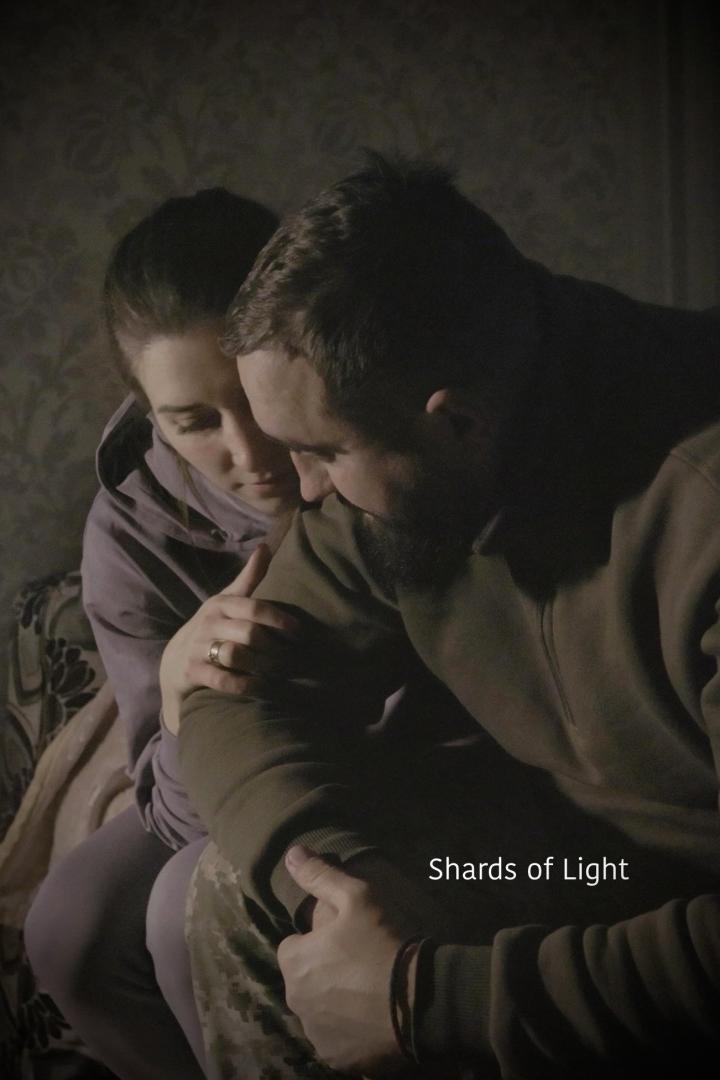 Ein Paar umarmt sich innig in einem dunklen Raum.