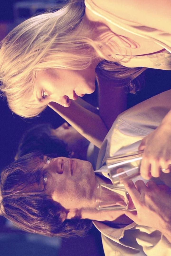 Eine Frau hält einem Mann zwei Glasröhrchen an den Hals.