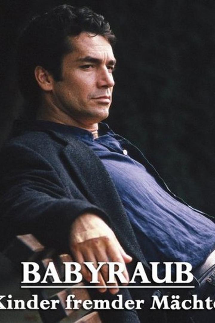 Ein Mann sitzt auf einer Bank, vermutlich eine Szene aus dem Film „Babyraub – Kinder fremder Mächte“.