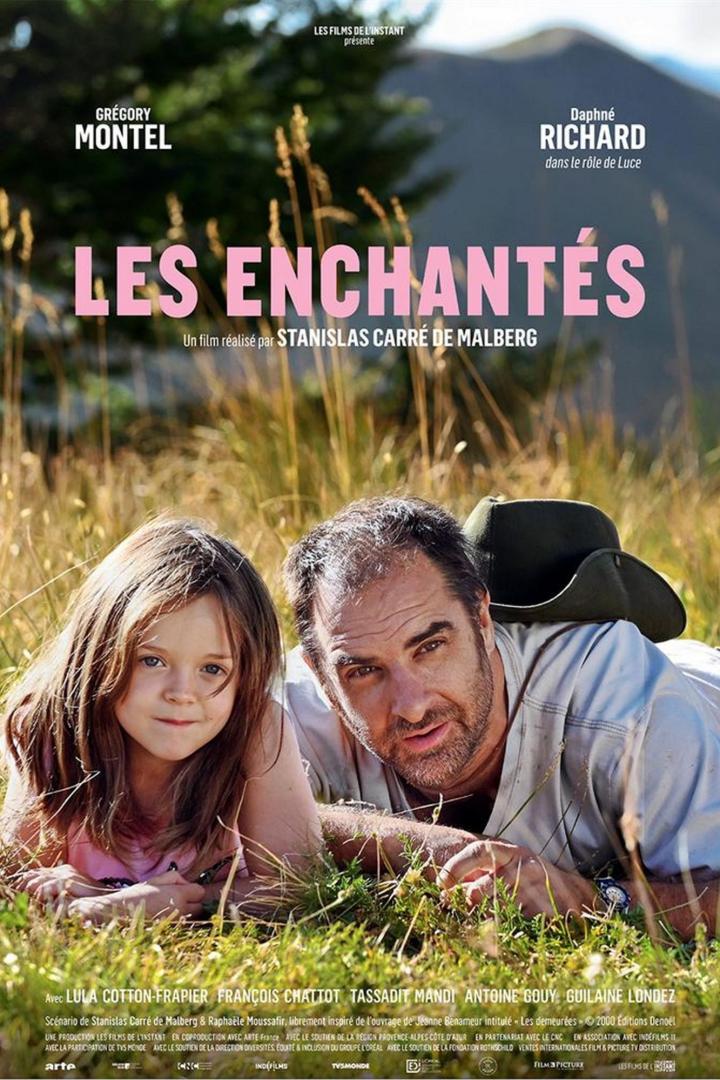 Das Filmplakat zu „Les Enchantés“ zeigt ein Mädchen und einen Mann, die im Gras liegen.