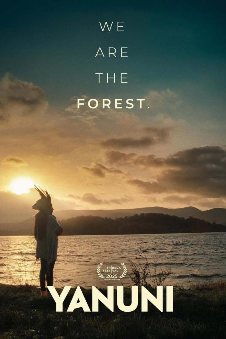 Ein Mann mit Kopfschmuck steht am Ufer eines Sees bei Sonnenuntergang, im Vordergrund der Filmtitel „Yanuni“.
