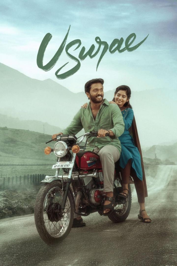 Ein Mann und eine Frau fahren auf einem Motorrad durch eine hügelige Landschaft.