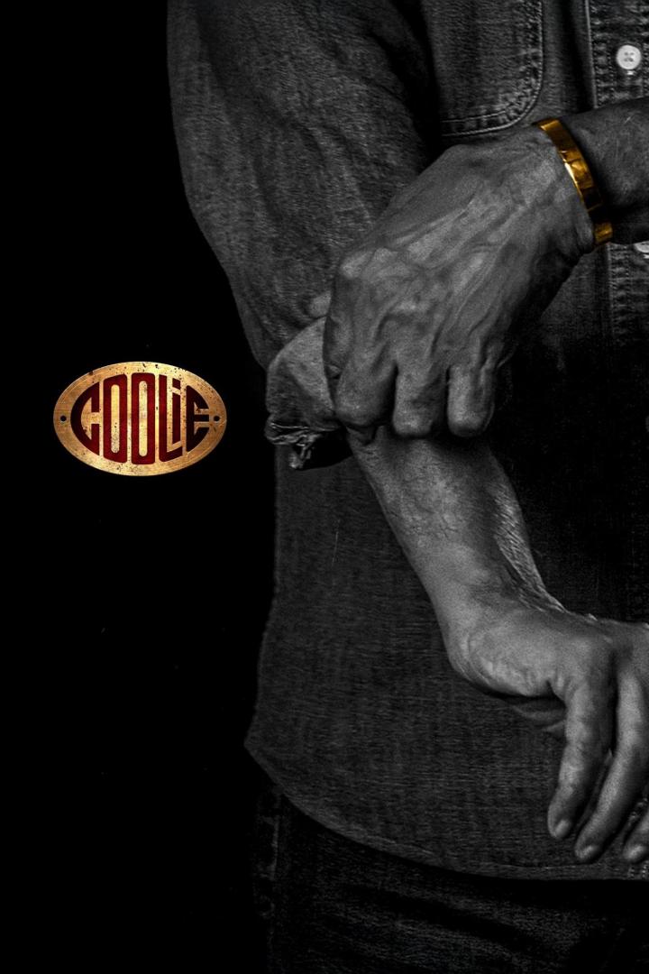 Ein Mann mit goldenem Armreif und dem „Coolie“-Logo im Vordergrund.