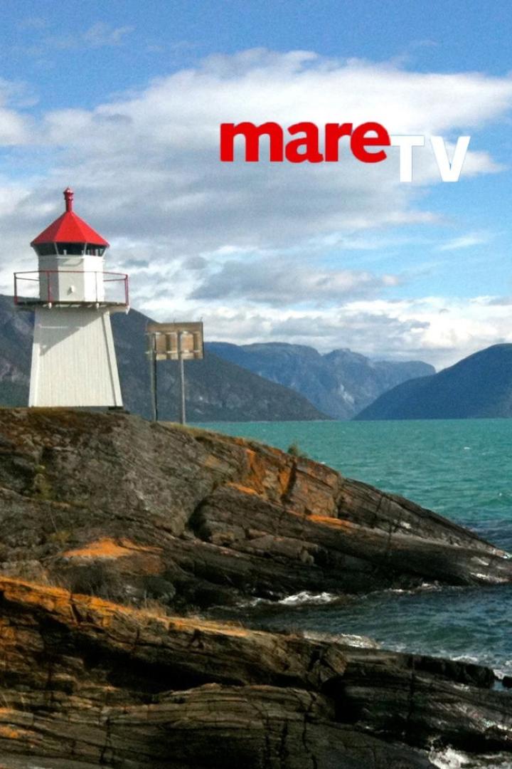 Ein Leuchtturm steht auf einer felsigen Küste mit Bergen und dem Schriftzug „mareTV“ im Hintergrund.