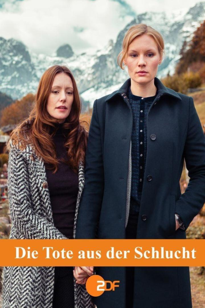 Zwei Frauen stehen vor einer Bergkulisse, möglicherweise eine Szene aus „Die Tote aus der Schlucht“.