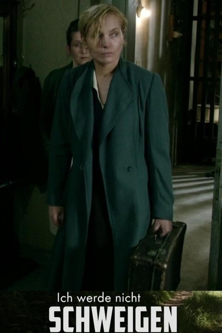 Eine Frau mit Mantel und Koffer, möglicherweise auf der Flucht.