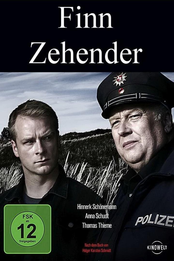 Das Filmplakat zu „Finn Zehender“ zeigt Hinnerk Schönemann und einen Polizisten vor einer Dünenlandschaft.