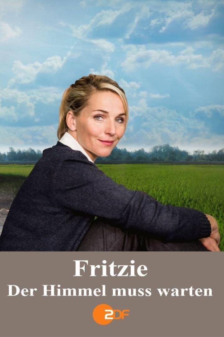Eine Frau sitzt vor einer grünen Wiese und einem bewölkten Himmel.