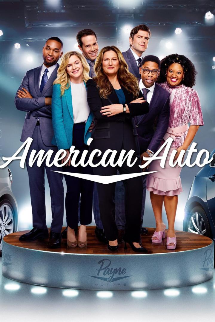 Die Besetzung der Fernsehserie „American Auto“ posiert auf einer Bühne vor zwei Autos.
