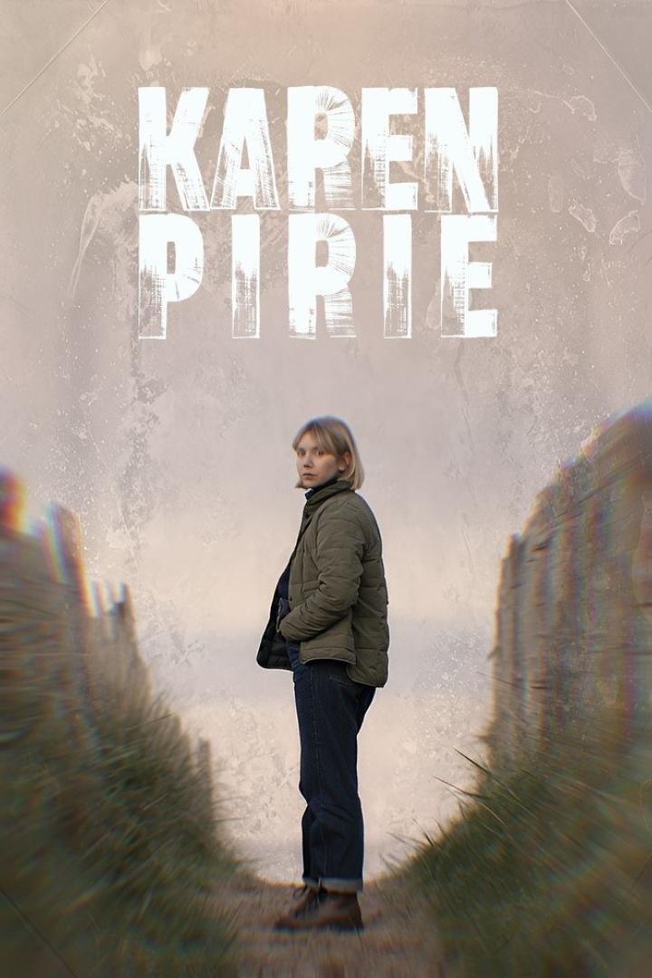 Eine Frau steht vor dem Hintergrund des Titels „Karen Pirie“ auf einem sandigen Weg.