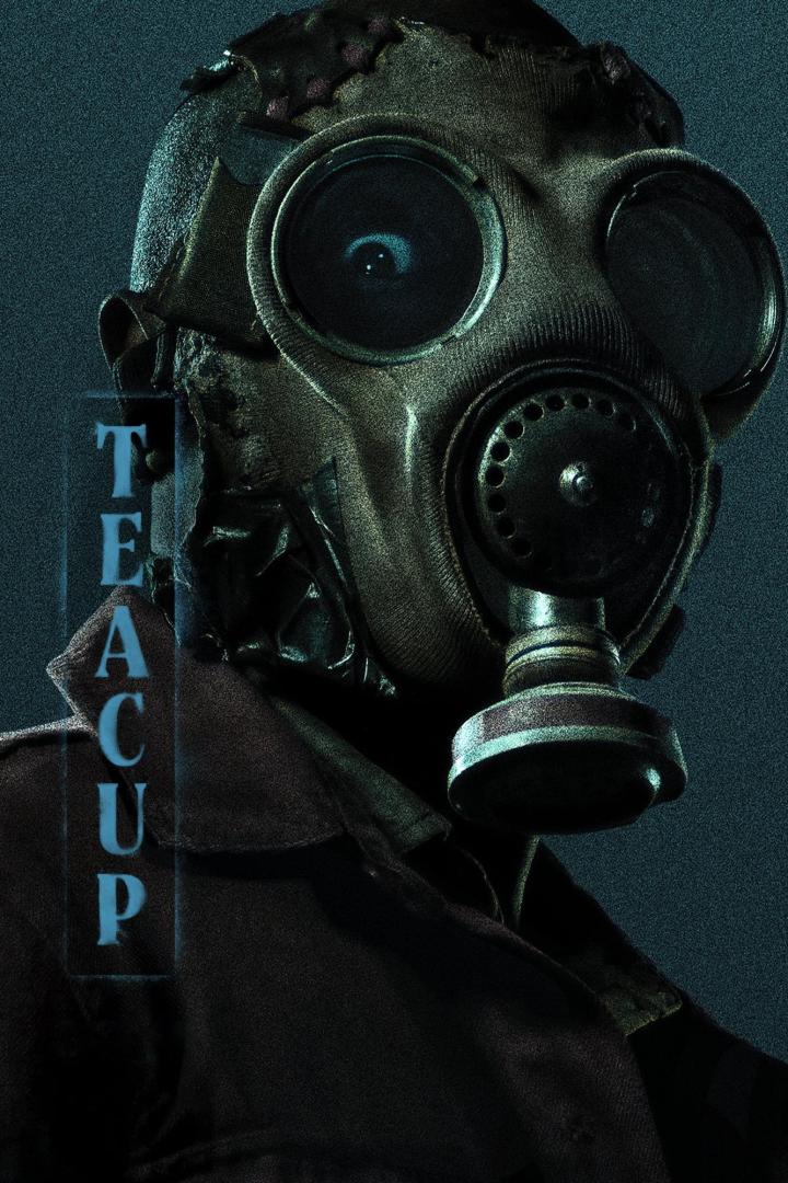 Eine Person mit einer beschädigten Gasmaske, neben der das Wort „TEACUP“ steht.