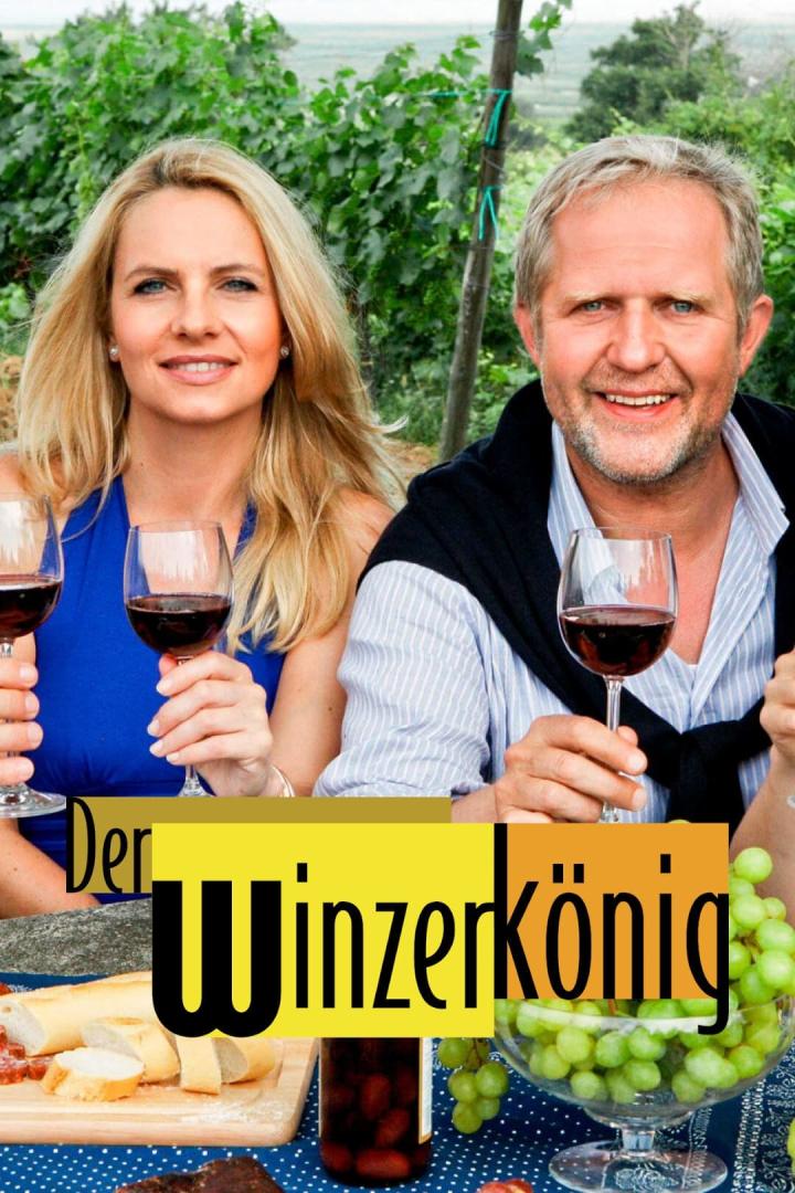 Ein Mann und eine Frau sitzen mit Weingläsern und Speisen vor einem Weinberg.