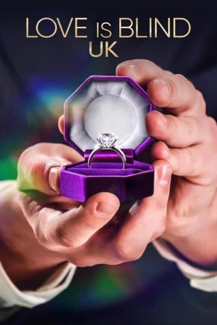 Ein Mann hält eine geöffnete, lilafarbene Schmuckschatulle mit einem Diamantring für „Love is Blind UK“.