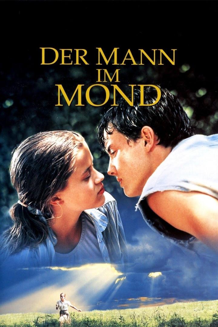 Das Filmplakat für „Der Mann im Mond“ zeigt ein junges Paar und eine Person auf einer Wiese.