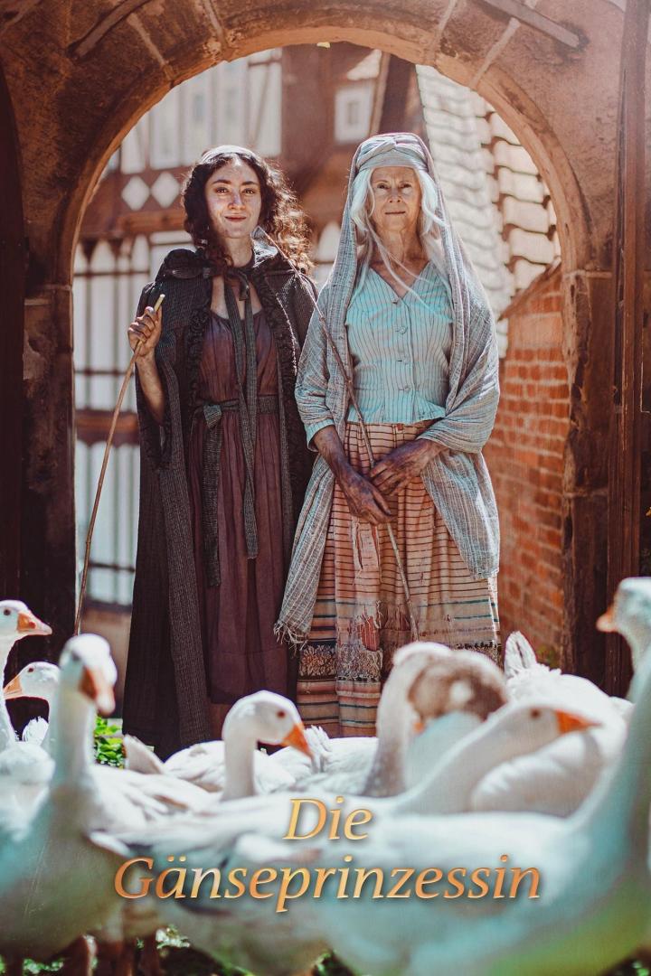 Zwei Frauen stehen vor einem Torbogen, umgeben von Gänsen, im Hintergrund der Titel „Die Gänseprinzessin“.