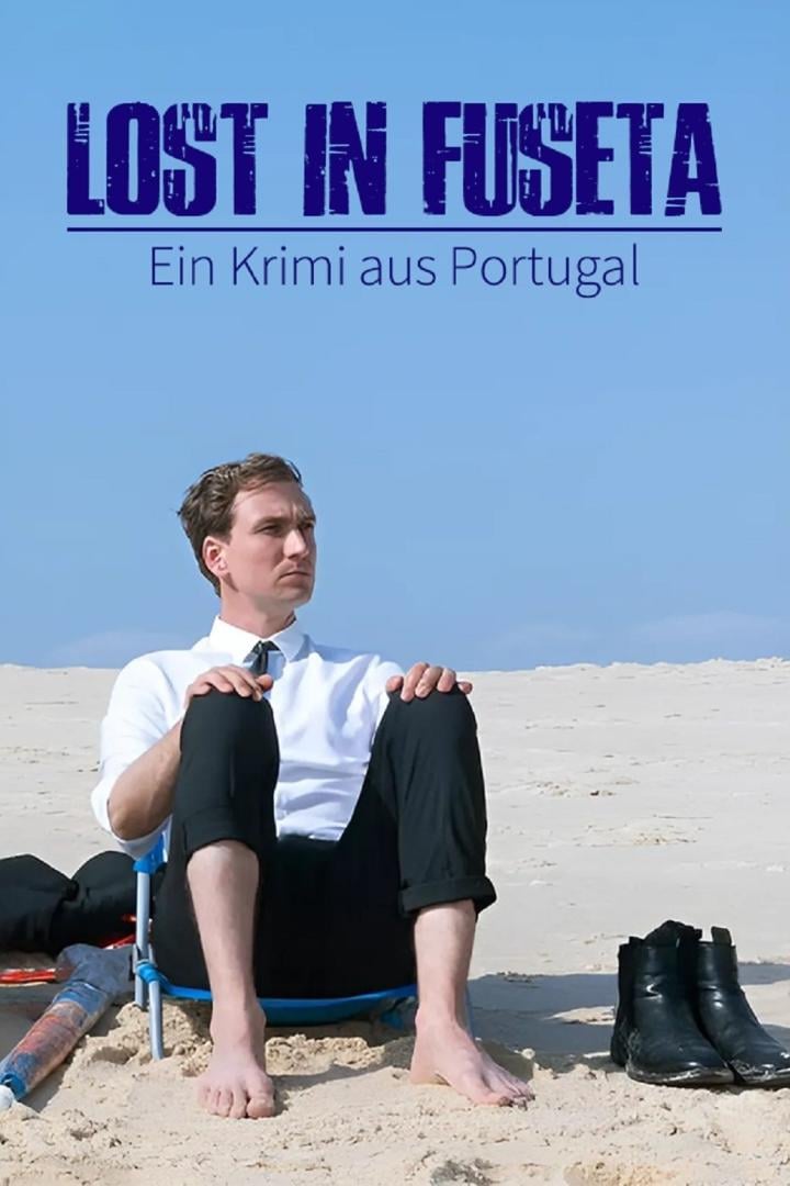 Ein Mann im Anzug sitzt barfuß am Strand, im Hintergrund das Filmplakat „Lost in Fuseta“.