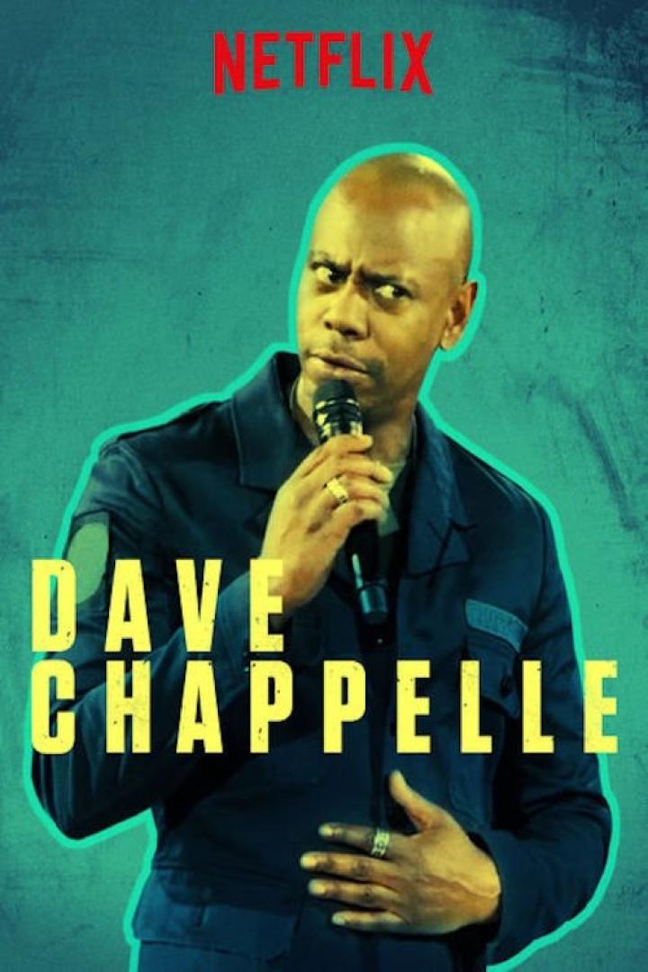 Der Comedian Dave Chappelle hält ein Mikrofon in der Hand.