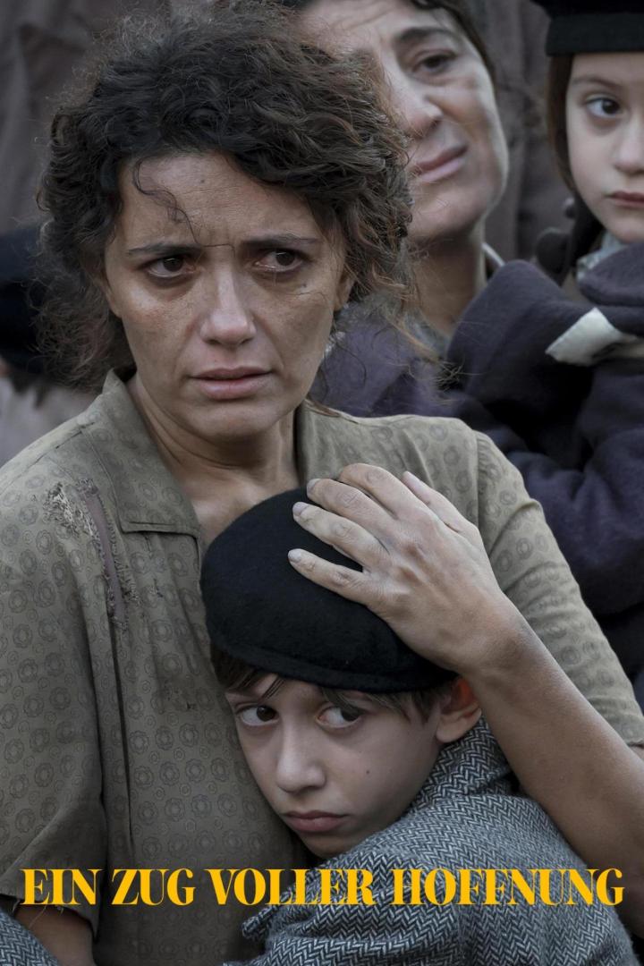 Eine besorgte Frau umarmt einen kleinen Jungen; andere Menschen stehen im Hintergrund.