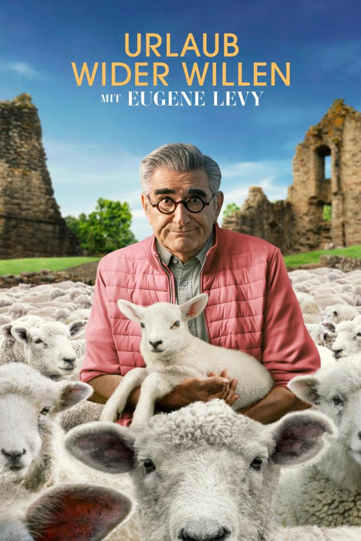 Eugene Levy hält ein Lamm in seinen Armen, umgeben von einer Schafherde.