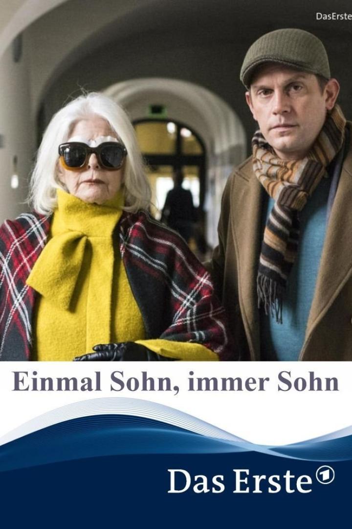 Eine ältere Frau mit Sonnenbrille und ein Mann stehen nebeneinander.