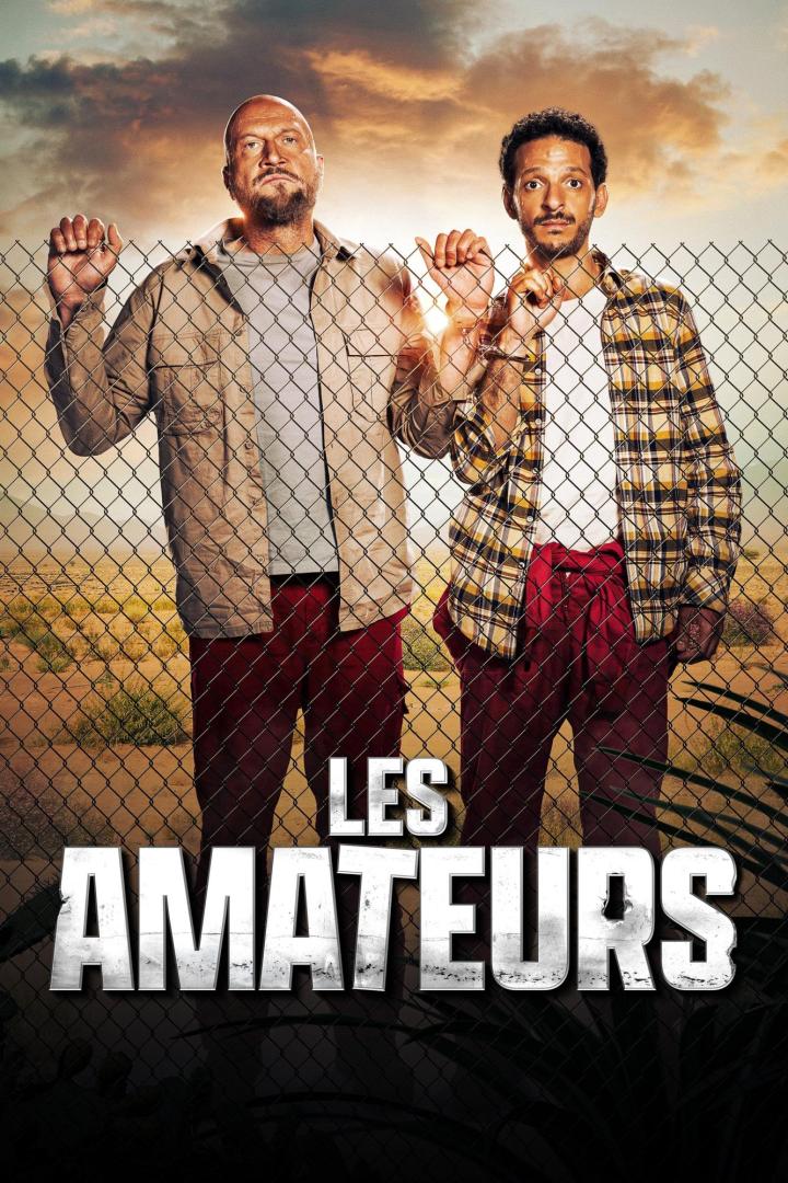 Zwei Männer stehen hinter einem Zaun im Filmplakat zu „Les Amateurs“.